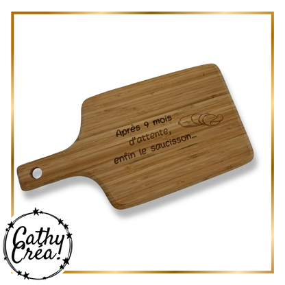 Détail de la gravure laser sur planche bambou, motif saucisson et message humoristique
